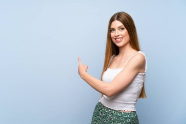 İzole edilmiş mavi arka planda genç bir kadın.