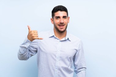 Izole mavi arka plan üzerinde kafkas yakışıklı adam telefon jest yapma