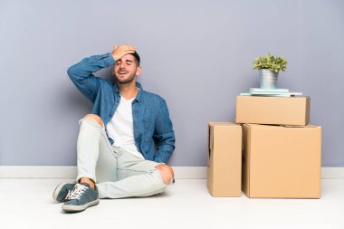 Yeni evinde kutular arasında dolaşan yakışıklı genç adam gülüyor