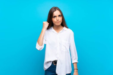 Kızgın jest ile izole mavi arka plan üzerinde genç kadın