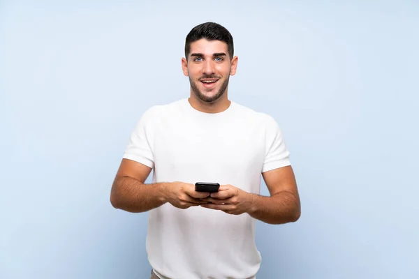 Kaukasischer Gutaussehender Mann Über Isoliertem Blauem Hintergrund Überrascht Und Sendet — Stockfoto