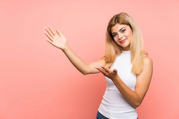 Adolescente Sur Fond Rose Isolé Étendant Les Mains Sur Côté — Photo