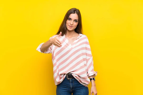 Jonge Vrouw Geïsoleerde Gele Achtergrond Schudden Handen Voor Het Sluiten — Stockfoto