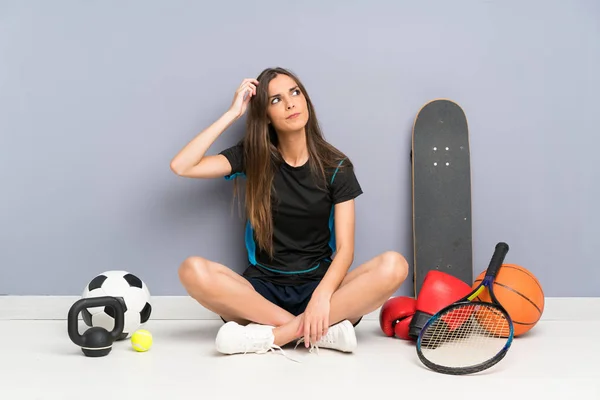 Jovem Mulher Esportiva Sentada Chão Com Dúvidas Com Expressão Facial — Fotografia de Stock
