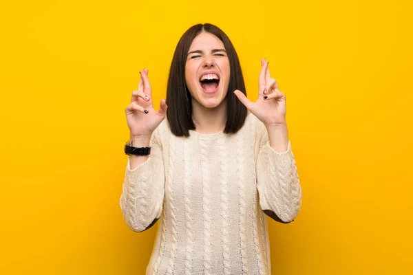 Jonge Vrouw Geïsoleerde Gele Muur Met Vingers Kruising — Stockfoto