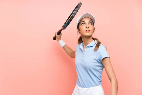 Junge Tennisspielerin über isolierte rosa Wand — Stockfoto