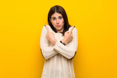 Izole sarı duvar üzerinde genç kadın şüpheleri olan laterals işaret
