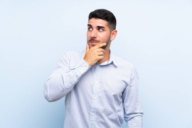 Izole mavi arka plan üzerinde Kafkas yakışıklı adam bir fikir düşünme