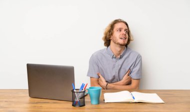 Bir dizüstü bilgisayar mutlu ve gülümseyen sarışın adam