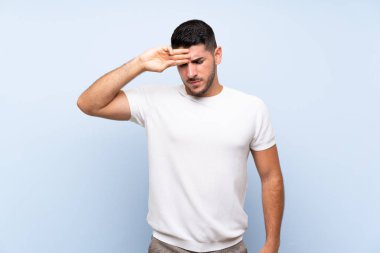 Yorgun ve hasta ifade ile izole mavi arka plan üzerinde Kafkas yakışıklı adam