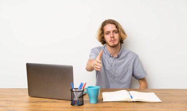 Iyi bir anlaşma kapanış için el sıkışan bir dizüstü bilgisayar ile Blonde adam