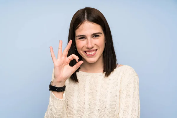 Молодая Женщина Над Изолированной Синей Стеной Показывает Знак Пальцами — стоковое фото