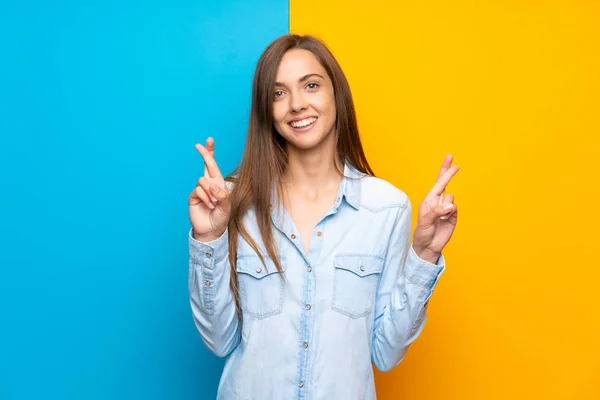 Mujer Joven Sobre Fondo Colorido Con Los Dedos Cruzando —  Fotos de Stock