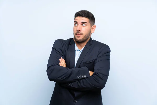 Hombre Guapo Sobre Fondo Azul Aislado Haciendo Gesto Dudas Mientras — Foto de Stock