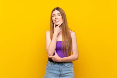 Izole sarı arka plan üzerinde genç kadın gülümseyerek
