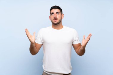 Izole mavi arka plan üzerinde Kafkas yakışıklı adam kötü bir durum tarafından sinirli