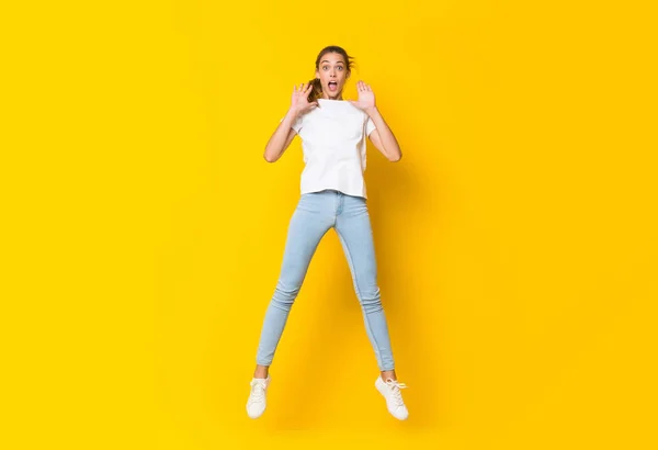 Jonge Vrouw Springen Geïsoleerde Gele Muur — Stockfoto
