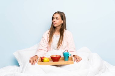 Kahvaltı yan görünümlü ile sabahlık genç kadın
