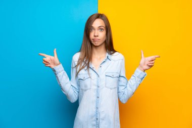 Renkli arka plan üzerinde genç kadın şüpheleri olan laterals işaret