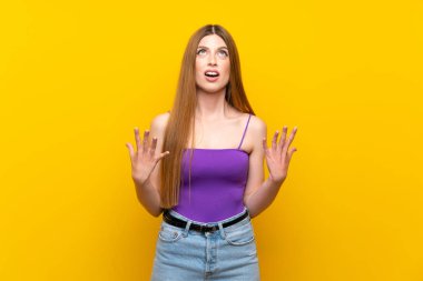 Izole sarı arka plan üzerinde genç kadın kötü bir durum tarafından sinirli