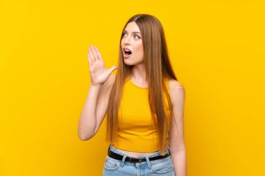 Sarı arka planda, ağzı açık bağıran genç bir kadın.