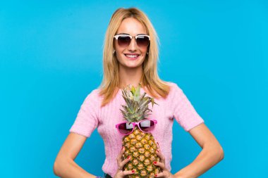 Güneş gözlüğü ile ananas tutan genç kadın