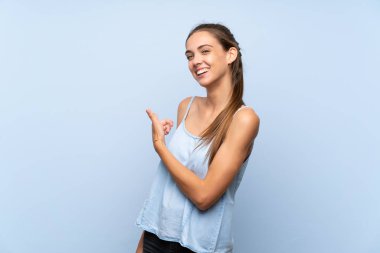 İzole edilmiş mavi arka planda genç bir kadın.