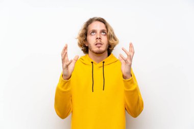 Beyaz duvar üzerinde Sweatshirt ile sarışın adam kötü bir durum tarafından hayal kırıklığına