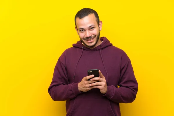 Kolumbianischer Mann Mit Sweatshirt Über Gelber Wand Sendet Eine Nachricht — Stockfoto