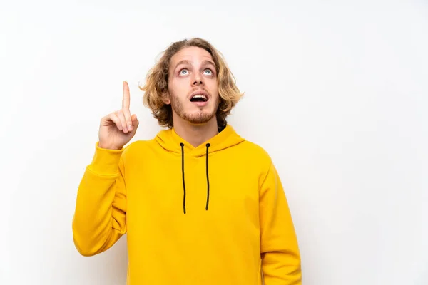 Beyaz Duvar Üzerinde Sweatshirt Ile Sarışın Adam Bir Parmak Kaldırırken — Stok fotoğraf