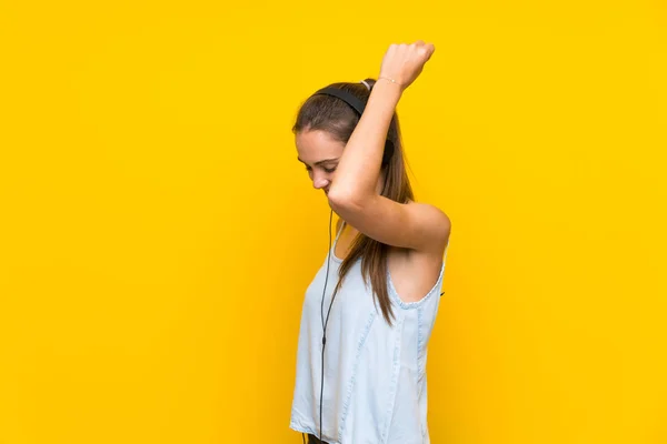 Zole Sarı Duvar Üzerinde Müzik Dinleyen Genç Kadın — Stok fotoğraf
