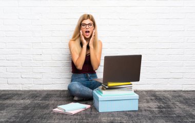 Gözlüklü dizüstü bilgisayarıyla yerde oturan genç kız şaşırttı