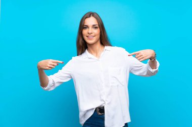 Soyutlanmış mavi arka plan gururlu ve kendini beğenmiş genç kadın.