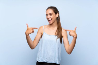 Soyutlanmış mavi arka plan gururlu ve kendini beğenmiş genç kadın.