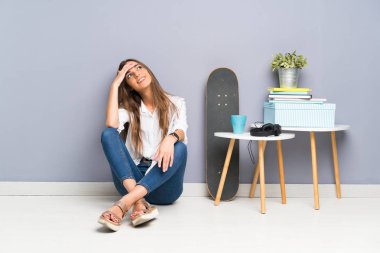 Genç bayan yerde oturmuş gülüyor.