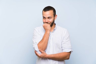 Kolombiyalı adam izole mavi duvar üzerinde şüpheleri olan