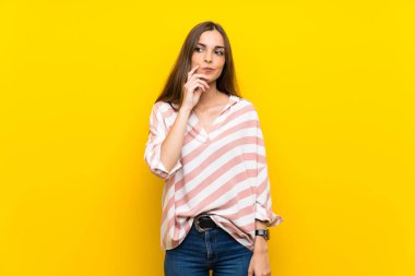 İzole sarı arka plan üzerinde genç kadın ön bakıyor