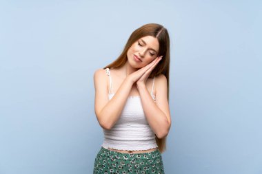 İzole mavi arka plan üzerinde genç kadın dorable ifade uyku jest yapma