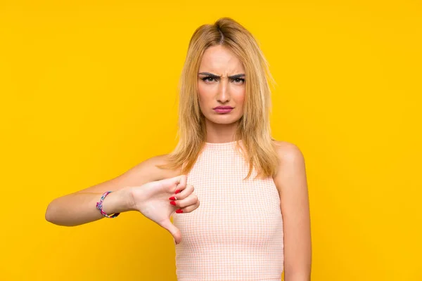 Jonge Blonde Vrouw Geïsoleerde Gele Muur Weergegeven Duim Omlaag Teken — Stockfoto