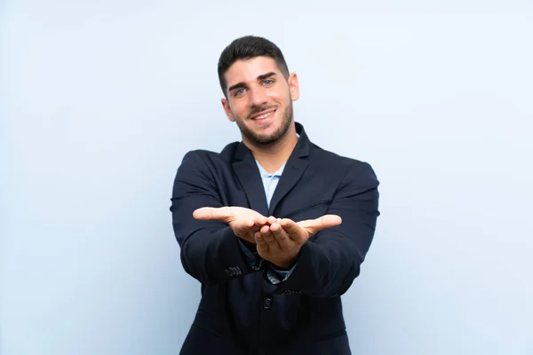 Hombre Guapo Sobre Fondo Azul Aislado Sosteniendo Espacio Copia Imaginario — Foto de Stock