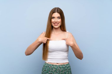 Soyutlanmış mavi arka planı olan genç bir kadın. Şaşırtıcı bir yüz ifadesi.