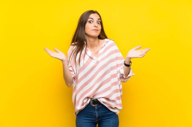 İzole edilmiş sarı arka planda genç bir kadın şüpheli hareketler yapıyor.