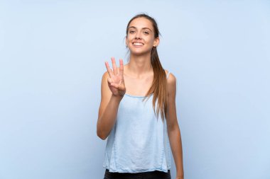 Izole mavi arka plan üzerinde genç kadın mutlu ve parmakları ile üç sayma