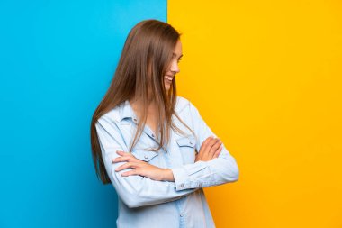 Renkli arka plan üzerinde genç kadın yan bakıyor