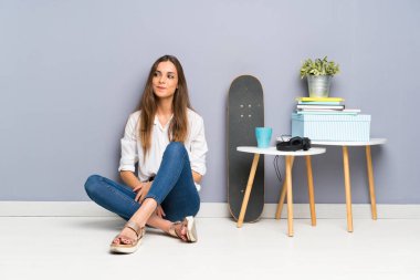 Genç kadın ayakta katta oturan ve yan bakıyor