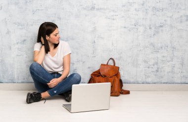 Öğrenci kadın bir fikir düşünerek katta oturan