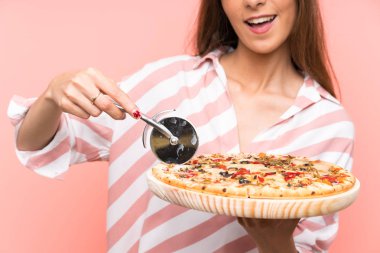 İzole pembe duvar üzerinde pizza tutan genç kadın