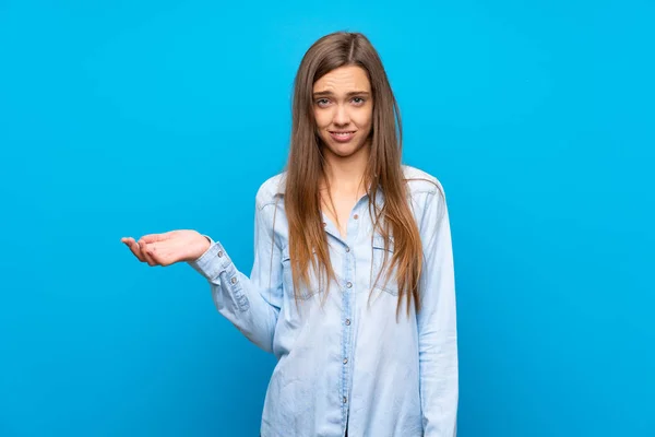 Jonge Vrouw Geïsoleerde Blauwe Achtergrond Maken Twijfels Gebaar — Stockfoto