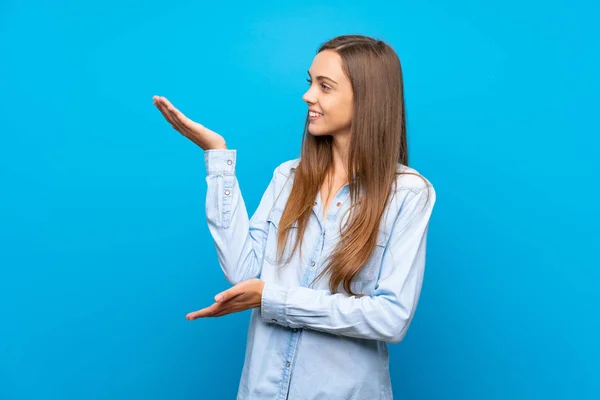 Giovane Donna Sfondo Blu Isolato Che Estende Mani Lato Invitare — Foto Stock