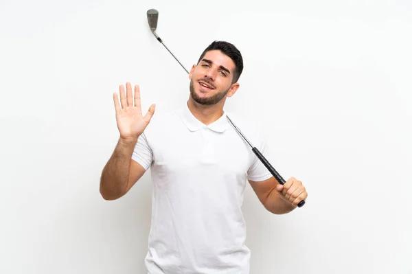 幸せな表情で手で敬礼孤立した白い背景の上にハンサムな若いゴルファープレーヤーの男 — ストック写真